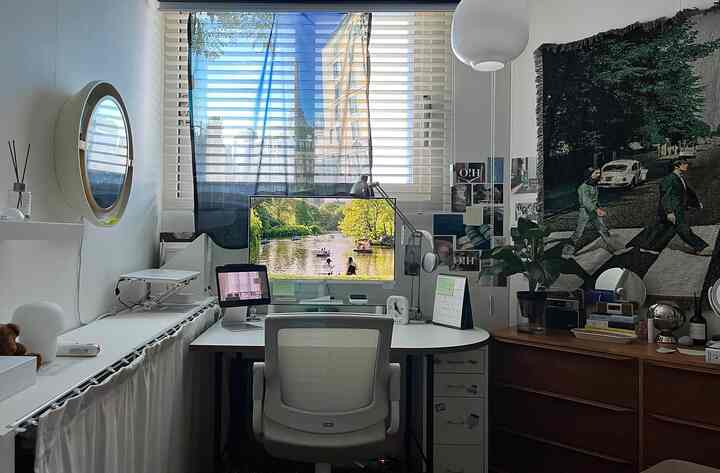 Modern home office with white and brown tones, featuring a desk and office chair centrally positioned