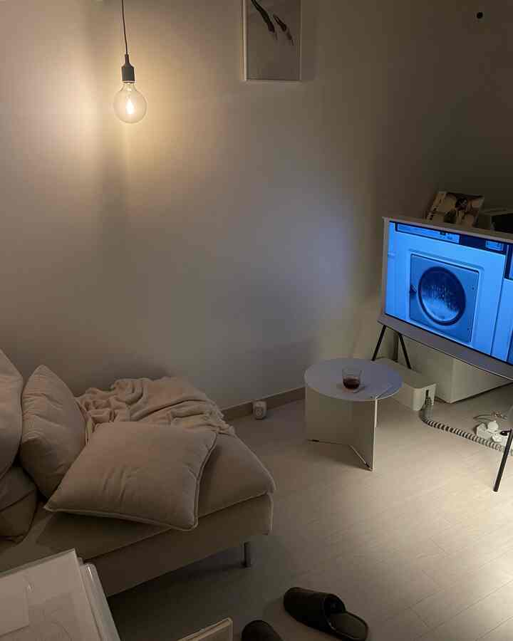 ベージュとホワイトのトーンのリビング、ペンダントライトとソファ、テレビが調和したシンプルモダンな空間