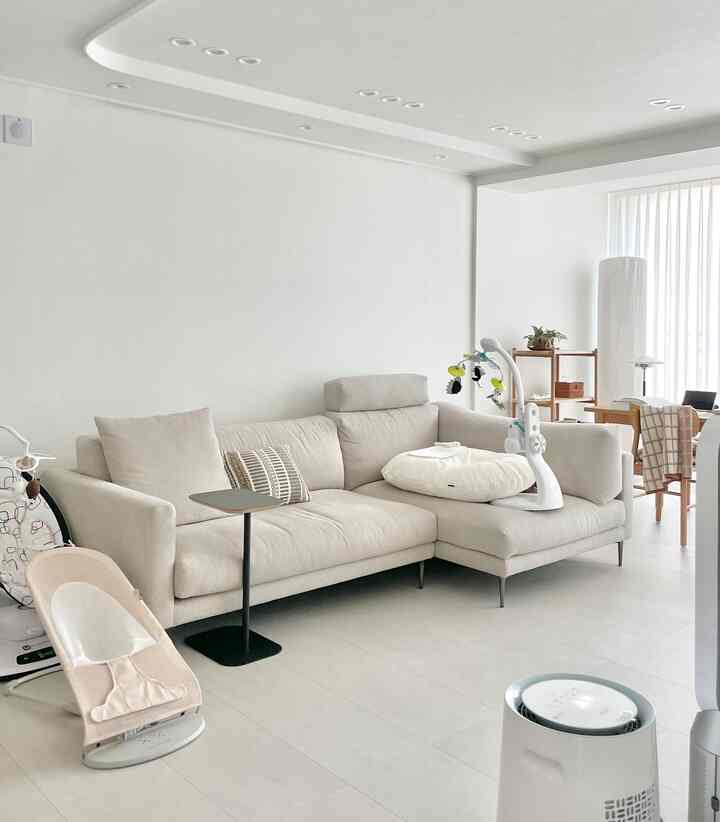 Bright natural beige-toned living room featuring beige sofa and baby products creating a cozy atmosphere