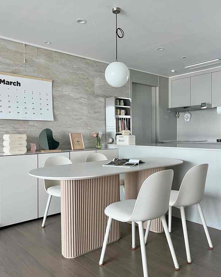 白とベージュの色調のダイニング、洗練されたダイニングテーブルと椅子が配置された清潔感のあるキッチン空間