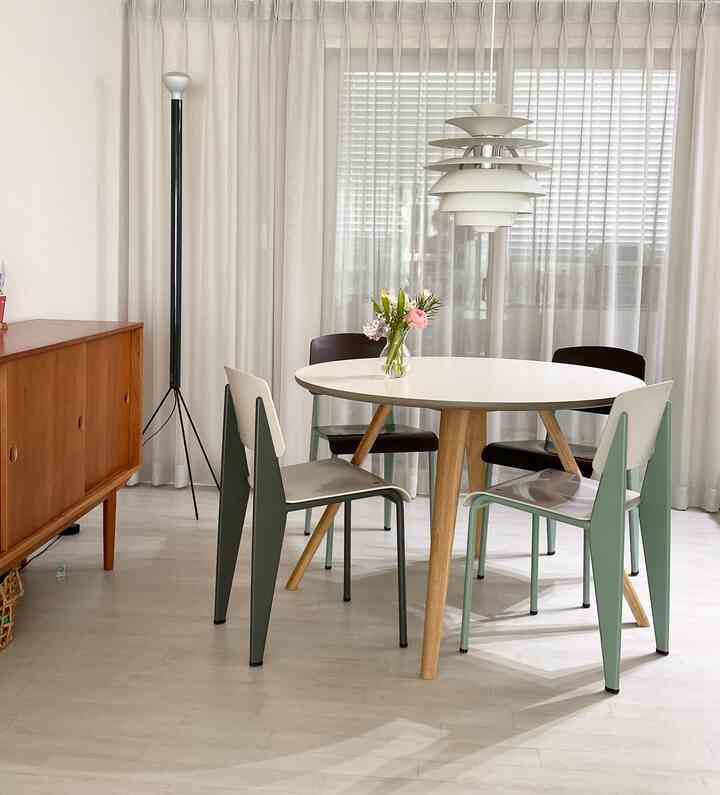 白を基調としたダイニングスペース、丸いテーブルと4つの椅子が配置されたシンプルでナチュラルなインテリア