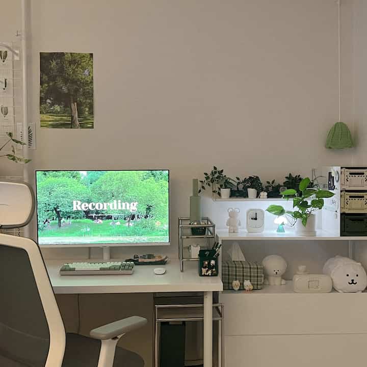 白と緑のトーンのホームオフィス、白い机と椅子、複数の植物が配置されたミニマルで清潔感のあるインテリア