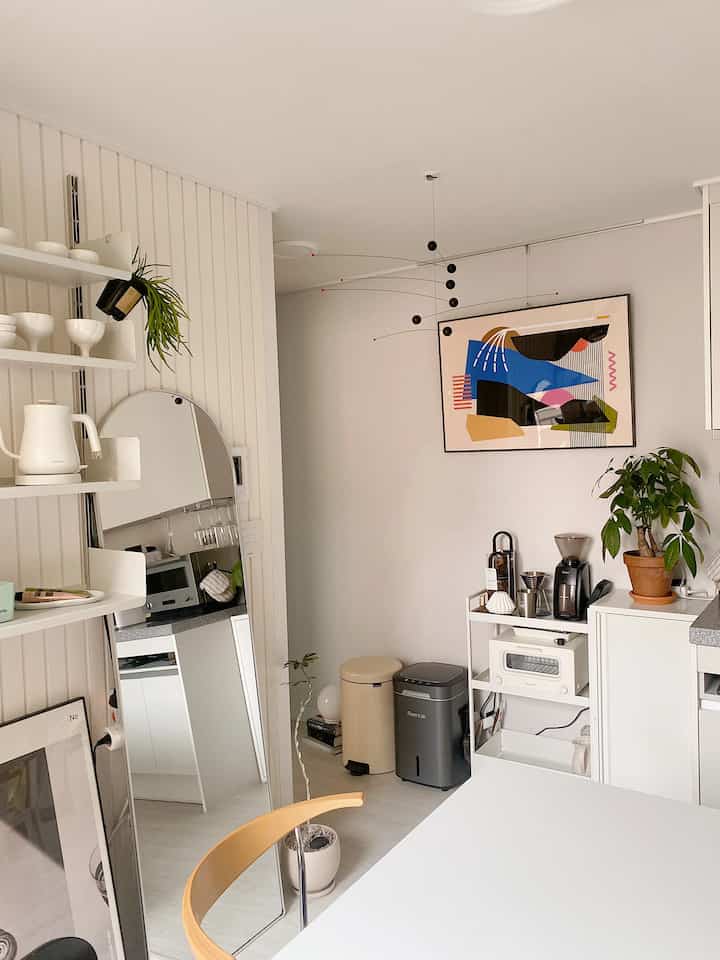 Karena ini adalah rumah pengantin baru kecil dengan luas 10 pyeong (10 pyeong), kami memanfaatkan ruang di lorong dengan menempatkan peralatan dapur seperti peralatan kafe rumah dan pemanggang roti. Saya menata rumah saya dengan warna putih modern dan menambahkan poster dengan berbagai warna dan tekstur sebagai aksen. 