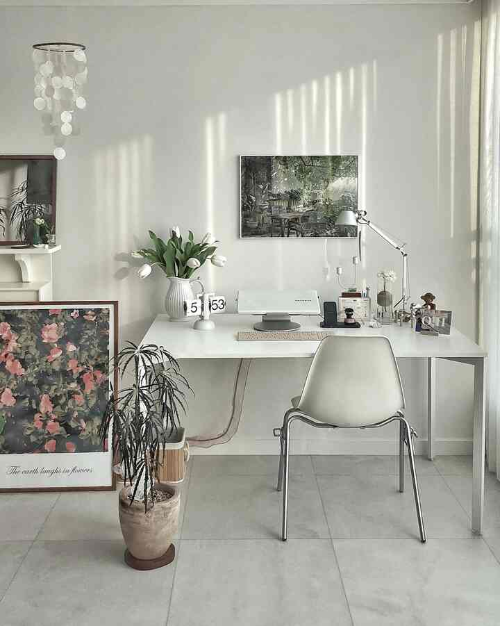 白を基調とした書斎、すっきりとしたデスクと自然を感じる絵画、植物が調和するシンプルでナチュラルなインテリア
