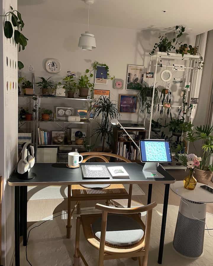Natural wood tones and black study and home office space, featuring numerous plants for a cozy and comfortable atmosphere