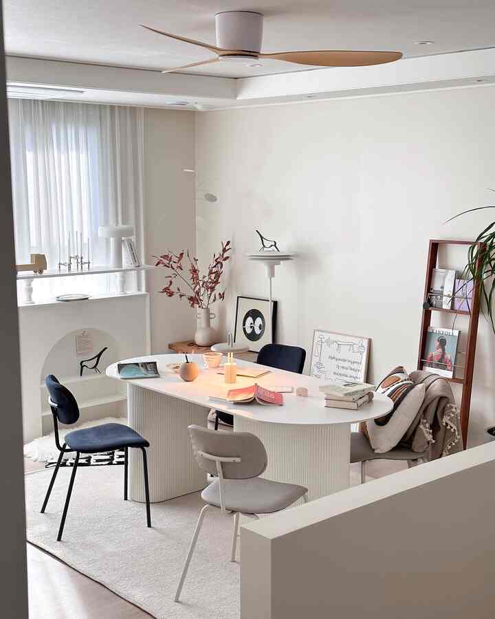 White and navy toned dining room featuring an oval dining table and chairs in a clean, cozy setting