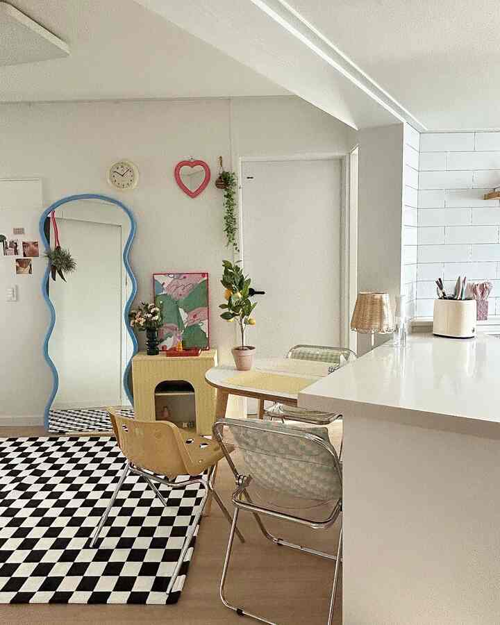 白とナチュラルトーンのリビング・ダイニング空間、チェック柄ラグとダイニングチェア、植物が配置された雰囲気のあるインテリア