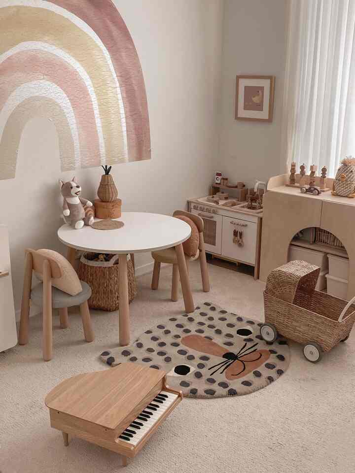 ナチュラル色調の子供部屋で、丸い子供用机と椅子、玩具収納が配置された雰囲気のある空間