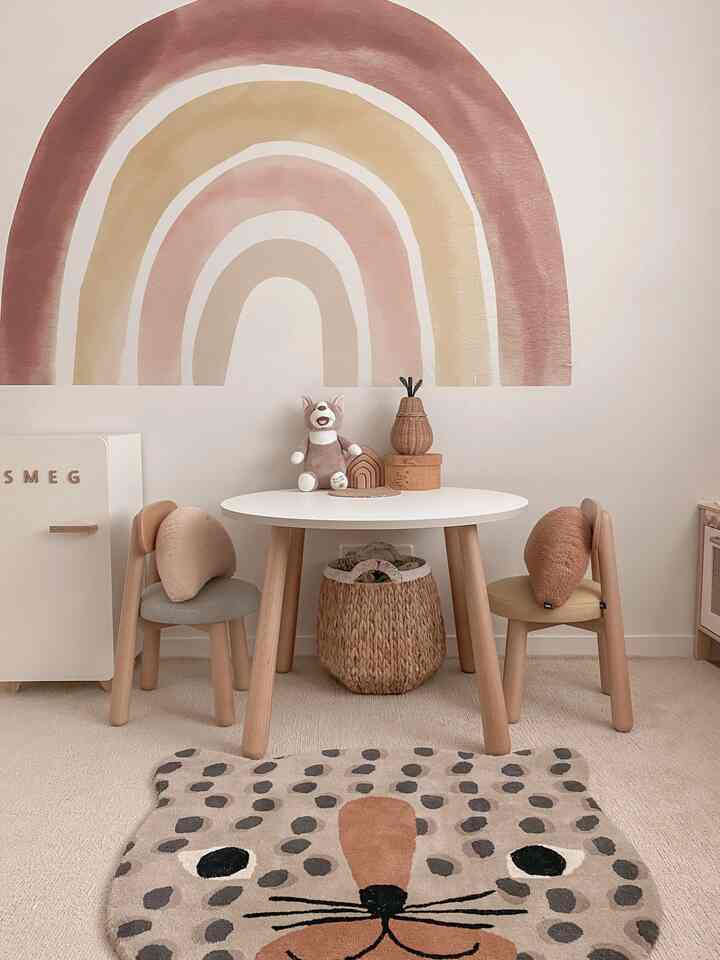 Warm wood tones and white blend in a kids' room featuring a round table and small chairs creating a cozy space