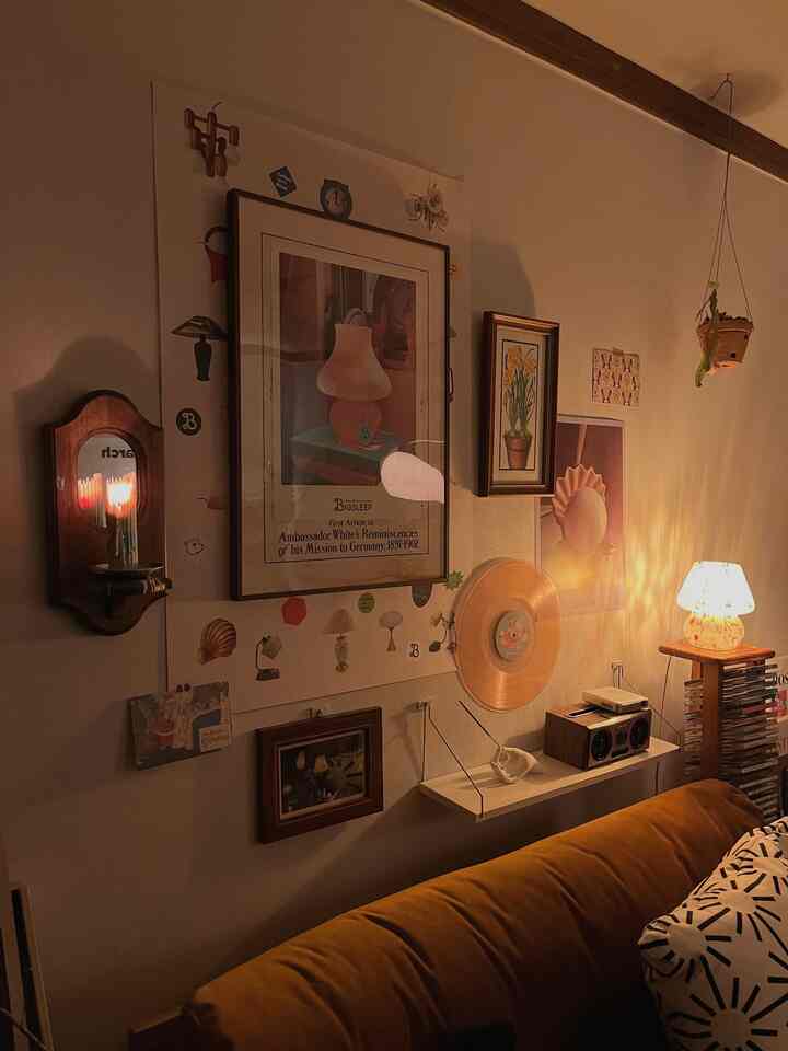 Warm brown-toned living room featuring a mustard sofa, vintage picture frames, and ambient lamps creating a cozy atmosphere