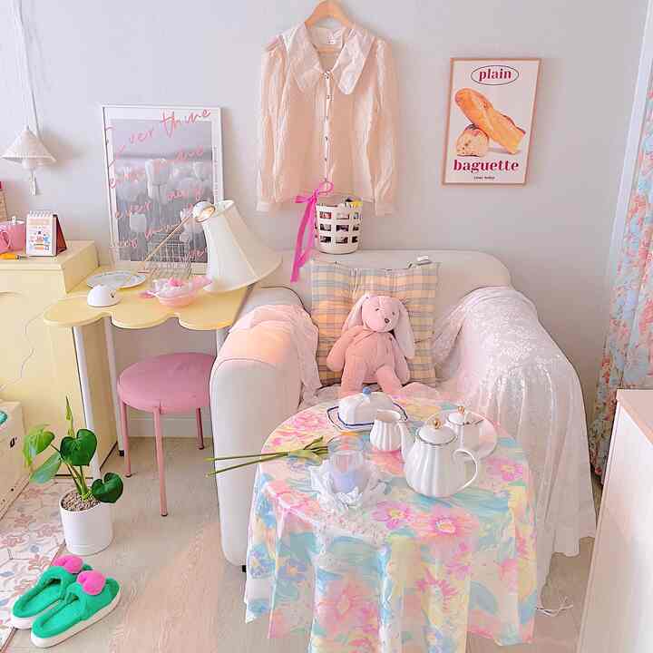 Pastel-toned living room sofa zone featuring white fabric sofa and floral tablecloth in a lovely space