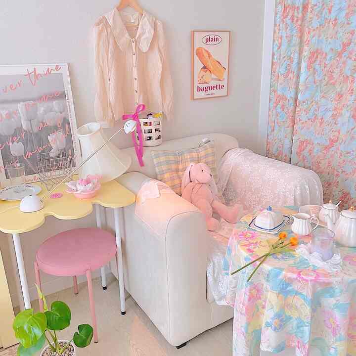 Ivory and beige toned living room featuring a sofa, pink stool, and floral curtains creating a cozy atmosphere