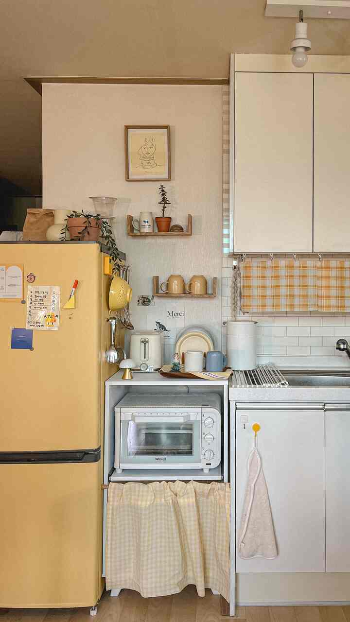 Yellow and natural toned kitchen featuring framed artwork centered on the wall, creating a cozy atmosphere