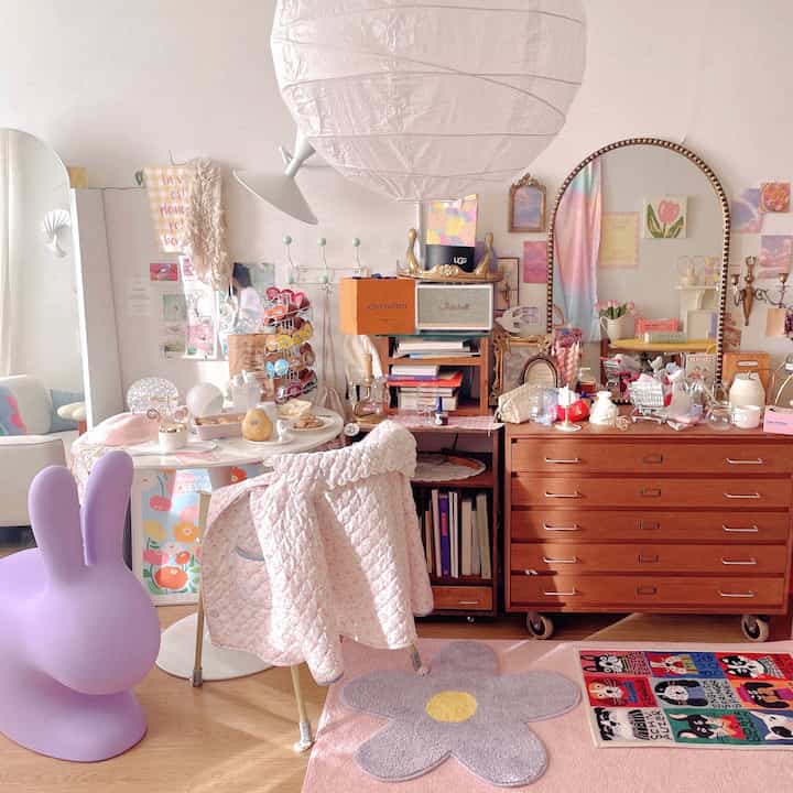 Pastel and natural toned cozy living room featuring rugs, vintage wooden dresser, and various decorative items creating a warm atmosphere