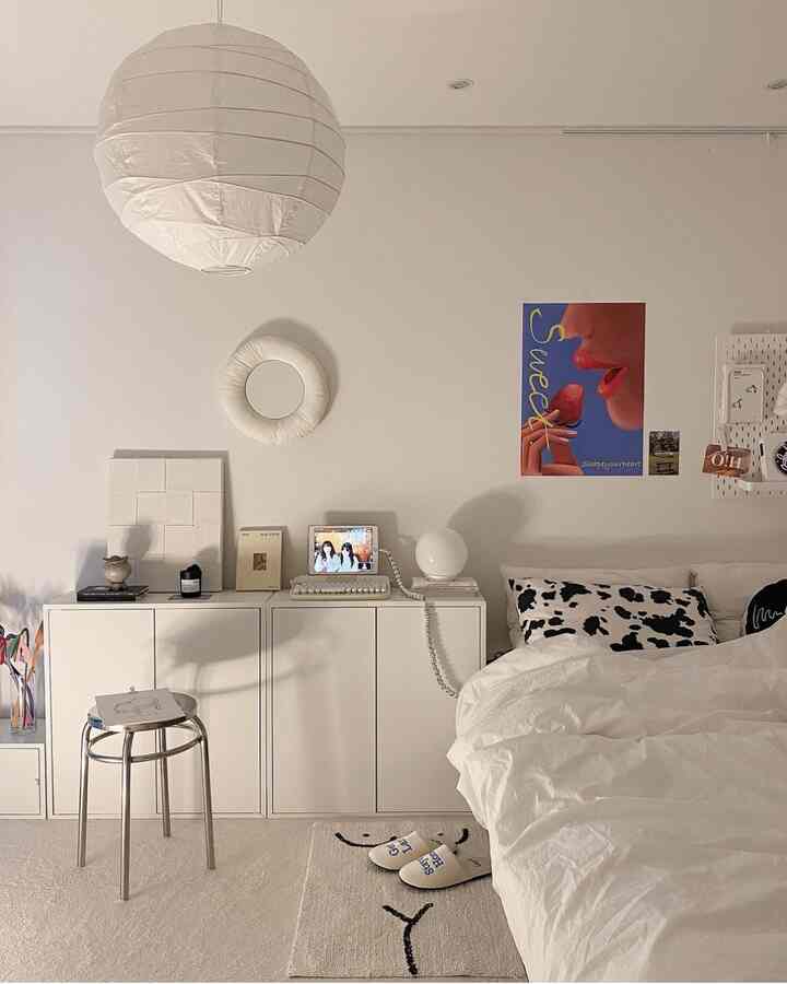 ホワイトトーンの寝室、白い家具とスツール、小物が調和したミニマルでホテルライクな雰囲気のあるインテリア