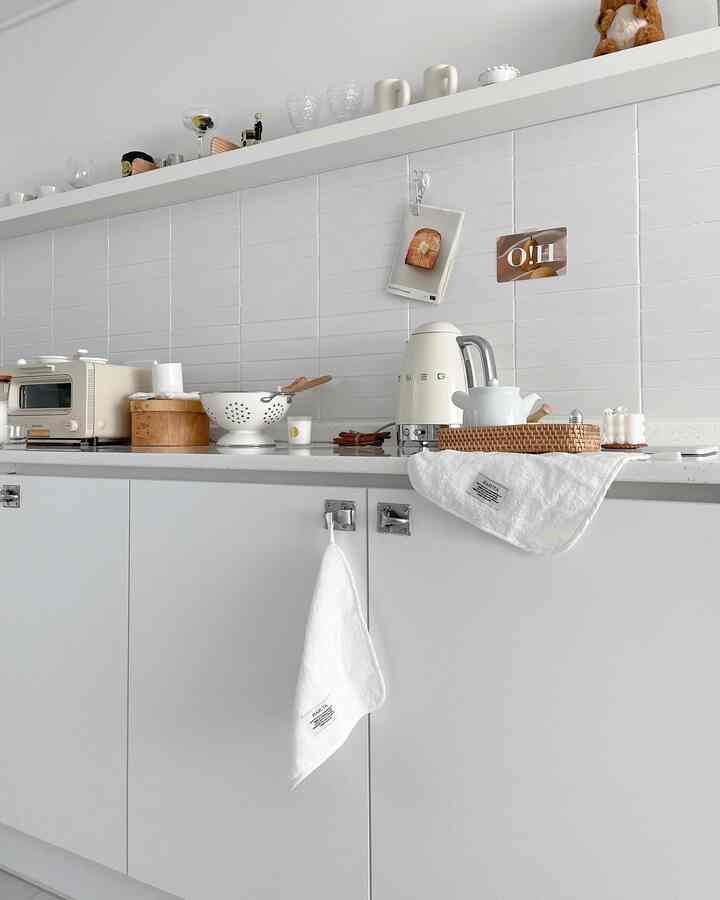 White-toned kitchen space featuring simple lower cabinets and kitchen utensils with a modern, clean interior