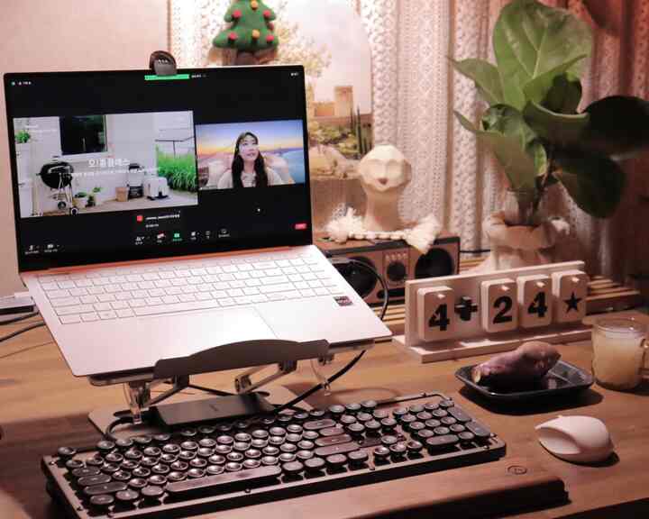 温かみのある木目調のホームオフィス、レトロなキーボードとノートパソコンが配置された居心地の良い在宅勤務環境