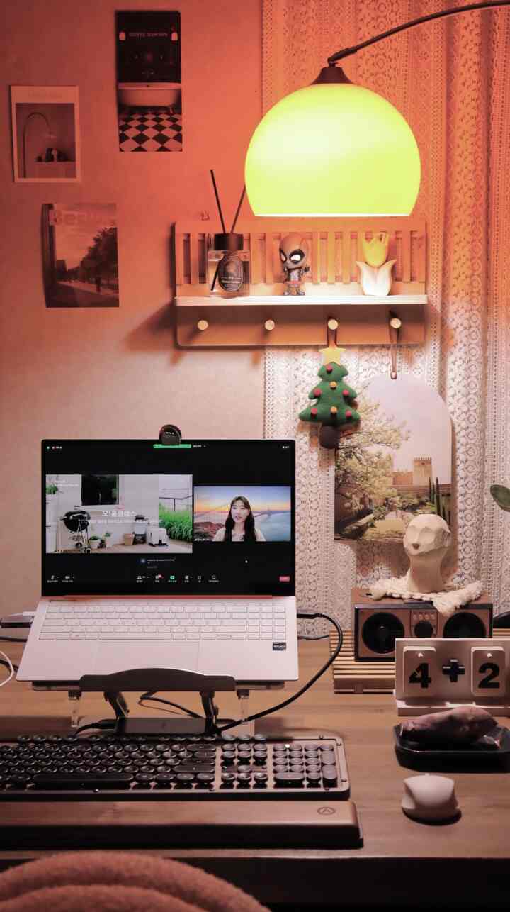 Warm wood tone home office space with lace curtains, featuring a laptop and vintage keyboard on a cozy desk setup