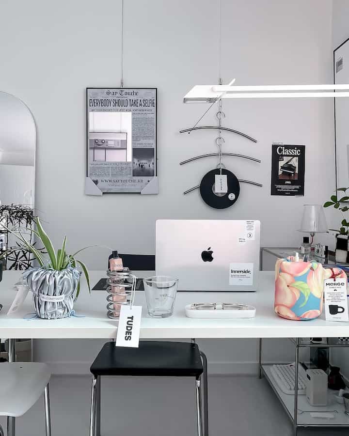 白と黒のトーンの書斎、白いデスクとコンバックチェア、ノートパソコンと植物が配置されたモダンなホームオフィス