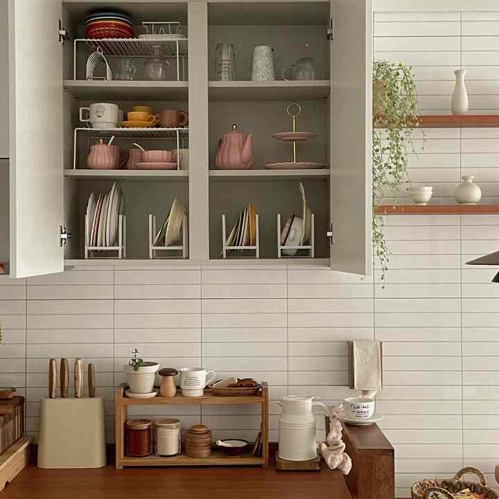 ベージュと木目調のキッチン空間、整然と並べられた棚とテラコッタ食器が自然な雰囲気を醸し出すインテリア