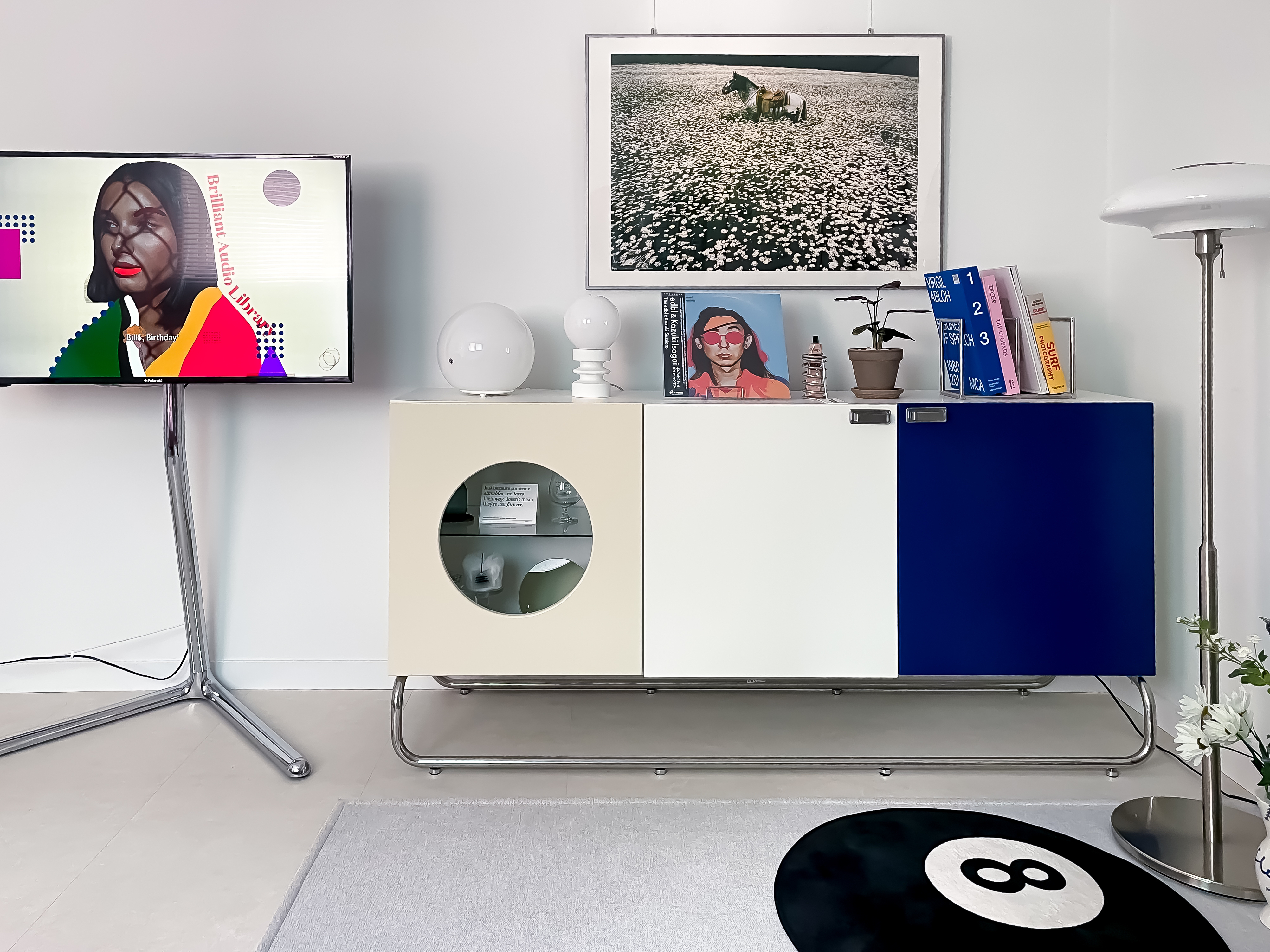 グレーとホワイトの色調のリビング、ブルーのキャビネットが配置されたモダンなインテリア