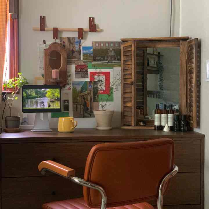 Brown-toned small room workspace featuring a wooden vanity and orange office chair creating a cozy atmosphere