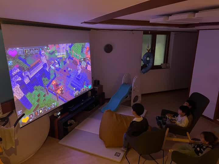 A white and blue-toned game room featuring children and a pet dog in a cozy and comfortable setting