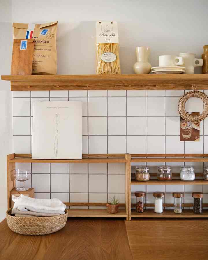 ナチュラルトーンのキッチン、木製棚と整頓された収納が配置された雰囲気のあるインテリア