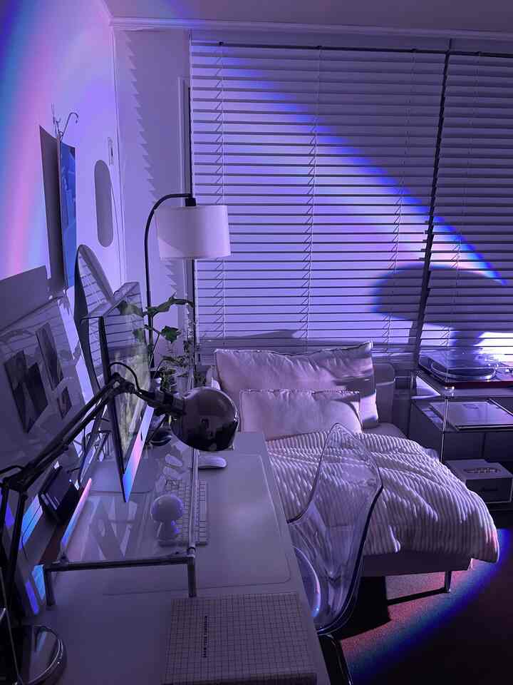 白と透明素材のワンルームホームオフィス、コンピューターデスクとソファベッドが配置されたシンプルなインテリア