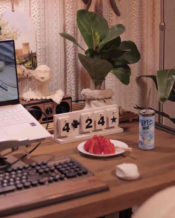 Home office space with ivory lace curtains and natural wood desk featuring a retro keyboard and green plants, creating a cozy atmosphere
