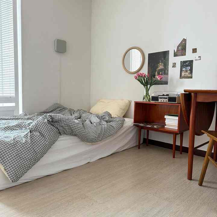 A natural and simple small bedroom in white and brown tones, featuring checkered bedding and wooden furniture