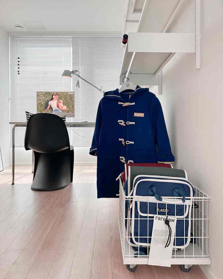 White and blue toned home office space featuring a simple modern desk and chair in a compact room