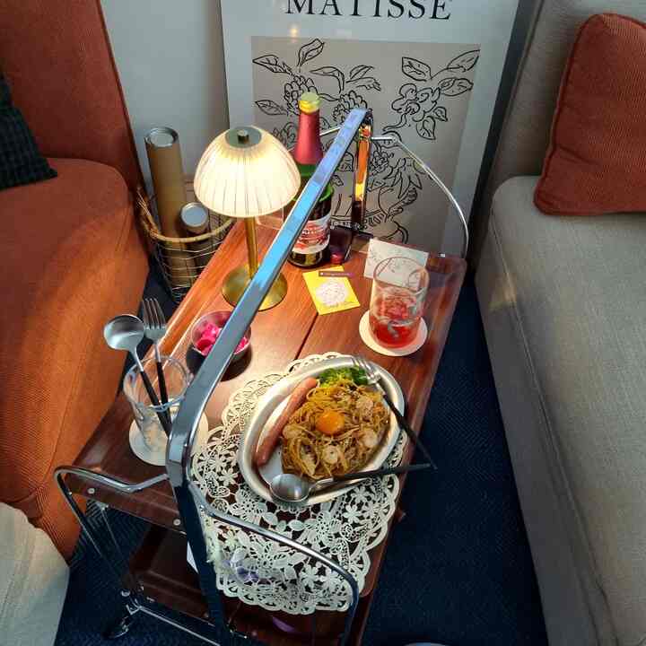 Warm brown toned living room featuring brown and light gray sofas with a wooden trolley table and home cafe drinks creating a cozy atmosphere