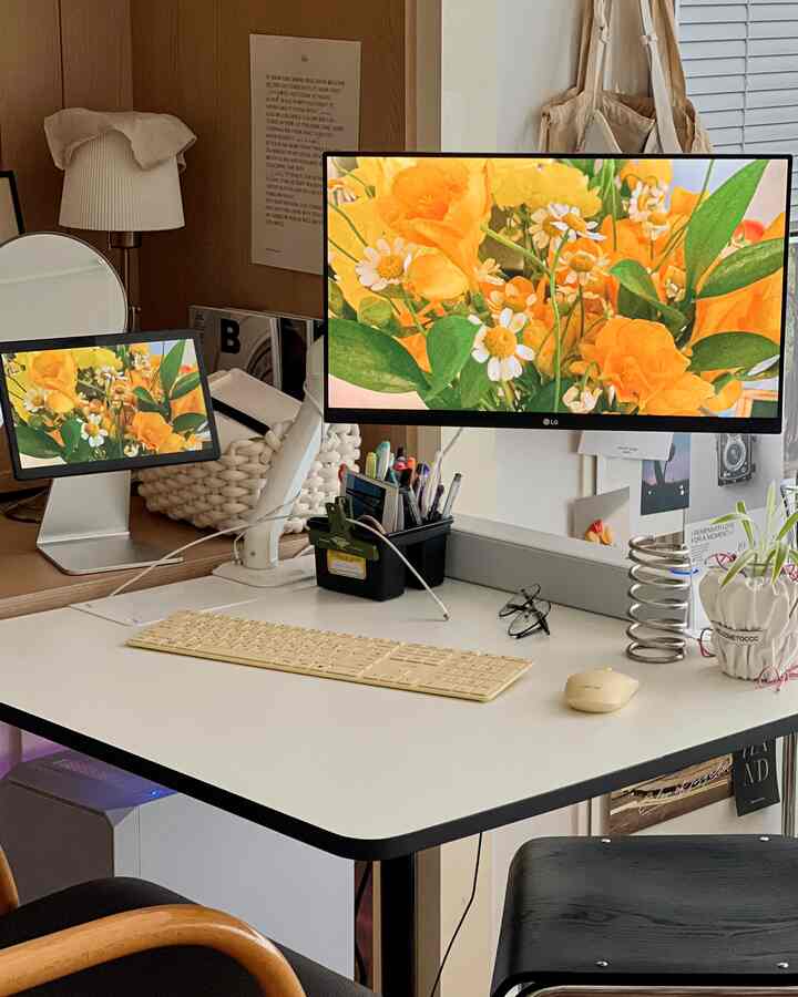 ホワイトとナチュラルブラウンの色調のワンルームホームオフィス、机の上にモニターとキーボードが整然と配置された雰囲気のあるインテリア