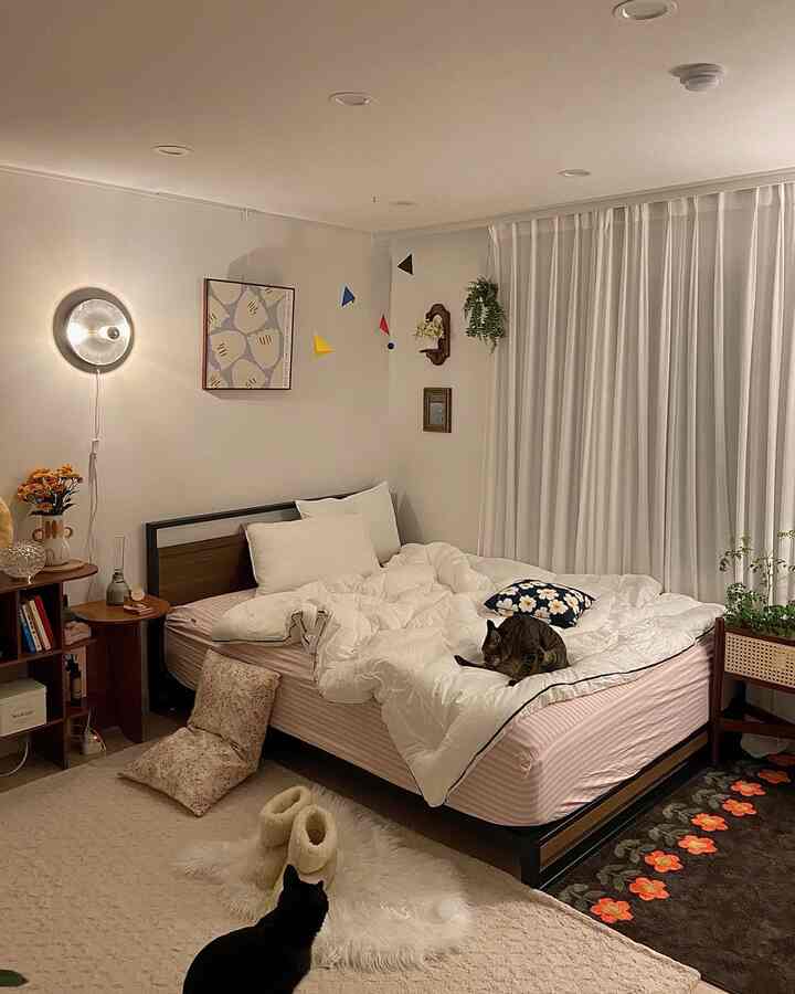 White and beige toned bedroom featuring two cats and natural modern style creating a cozy atmosphere