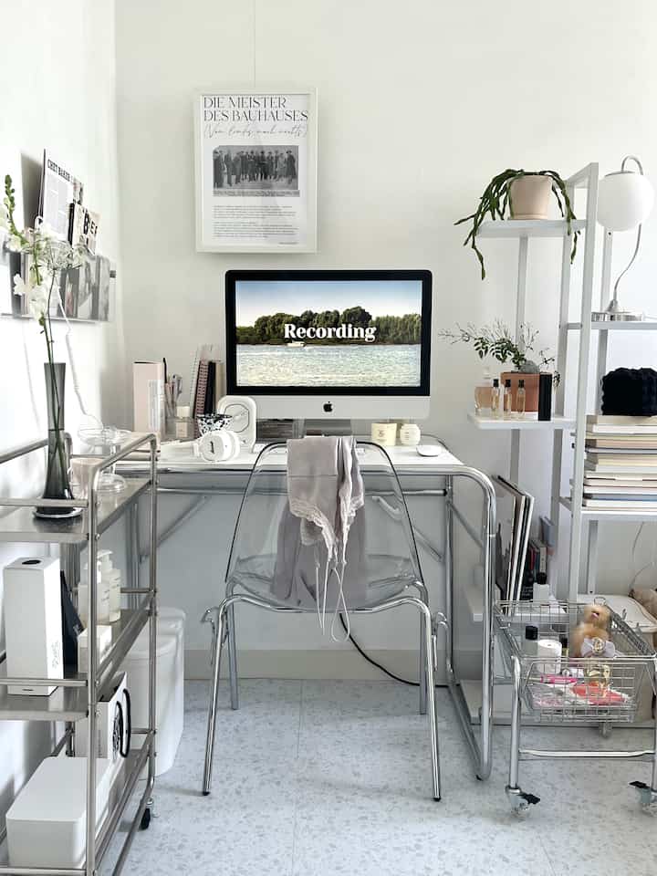White and transparent materials blend in a simple modern home office, featuring desk, bookshelf, and decor items in a clean workspace