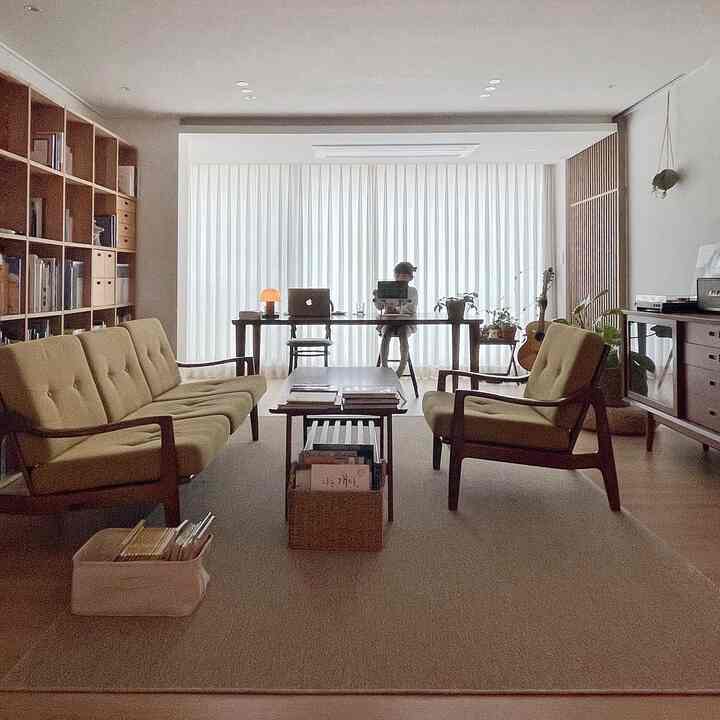 Beige and wood-toned living room study space featuring wooden furniture and yellow sofa, presenting a natural modern interior