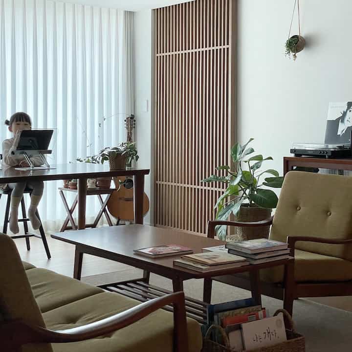 木目調でナチュラルな色調のリビングとダイニング、ダイニングチェアに座る子供がいる温かみのある雰囲気の空間