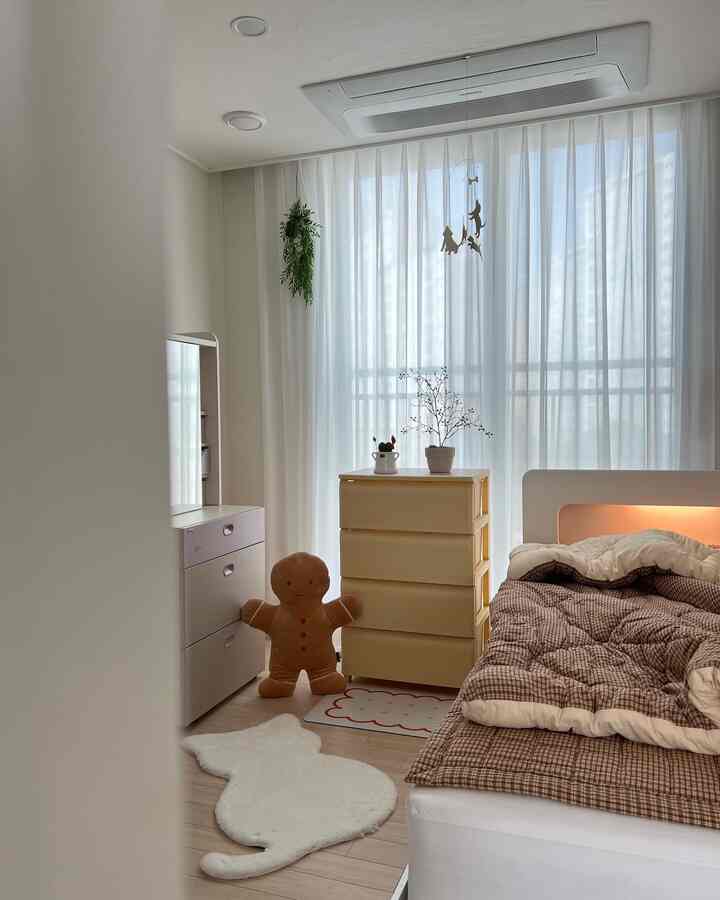 A white and brown toned kids' room featuring a bed and dressers with a cozy atmosphere