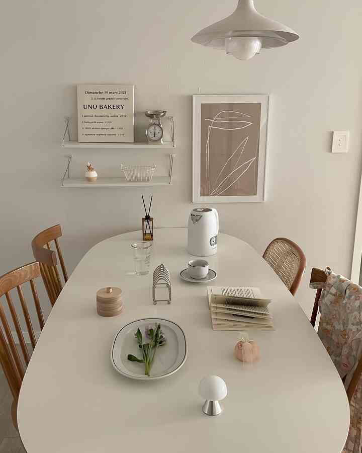 Dining room in white and brown tones featuring a simple dining table with wooden chairs, creating a cozy atmosphere