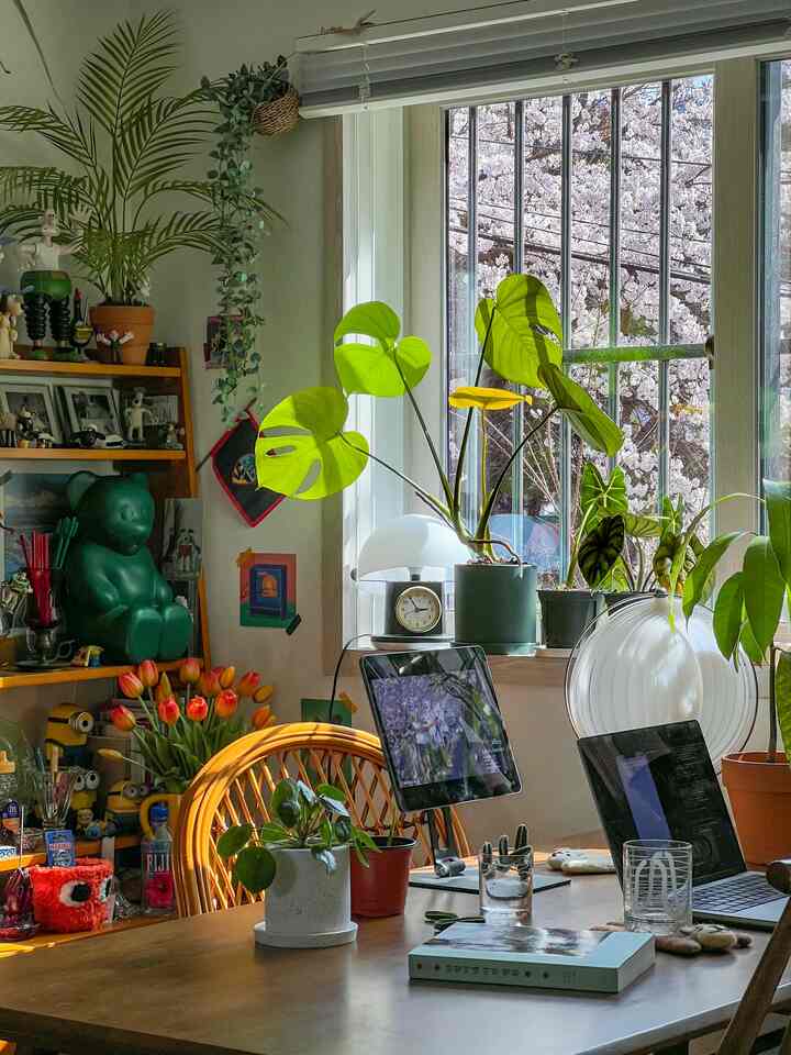 白い壁と自然な色調の6畳のホームオフィス、植物とノートパソコンが配置された雰囲気のあるインテリア