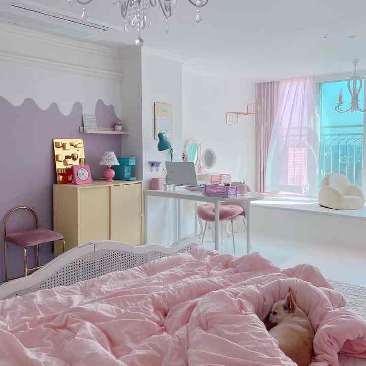 White and pink toned bedroom featuring a small dog on the bed and a bright coffee machine, creating a lovely atmosphere