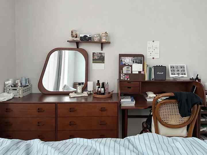 Natural brown-toned bedroom featuring wooden furniture and a large mirror with cozy atmosphere