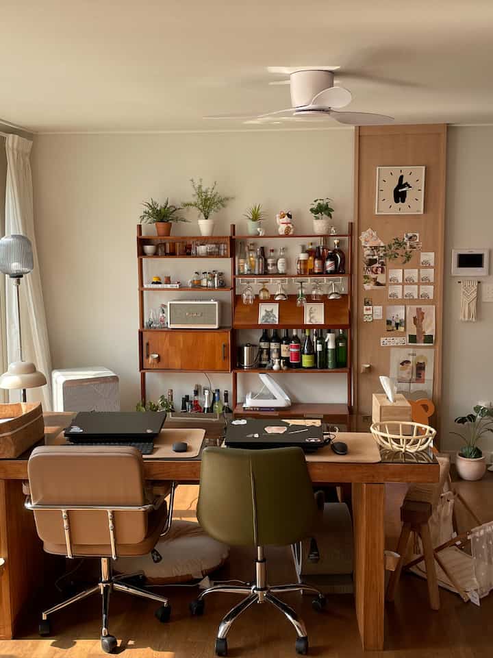 木目調と自然光が調和するホームオフィス空間、木製デスクとオフィスチェアが配置された居心地の良いリビング