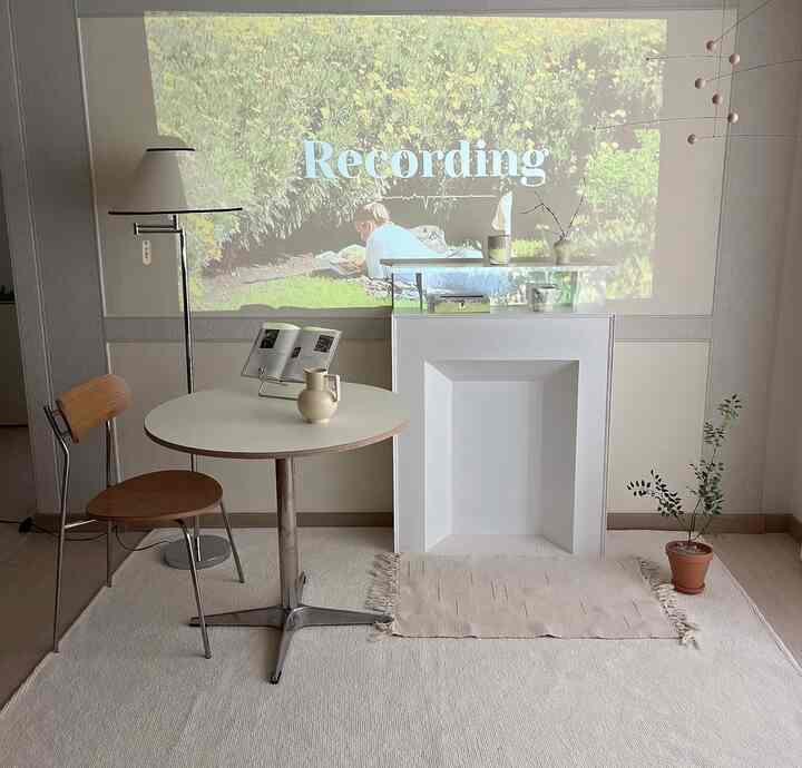 Beige and white toned living room featuring round table and floor lamp with simple natural atmosphere