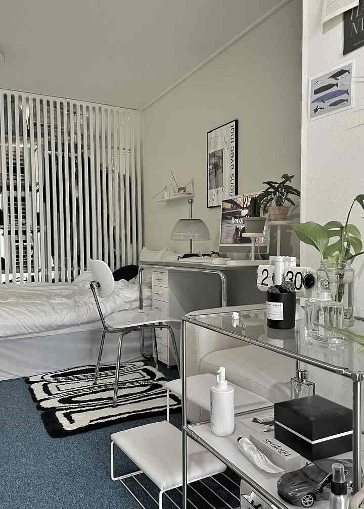 White and gray toned bedroom featuring a desk and chair setup with a minimalist modern interior design