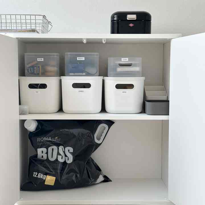 White-toned storage cabinet in a small room featuring organized MUJI and DAISO storage cases