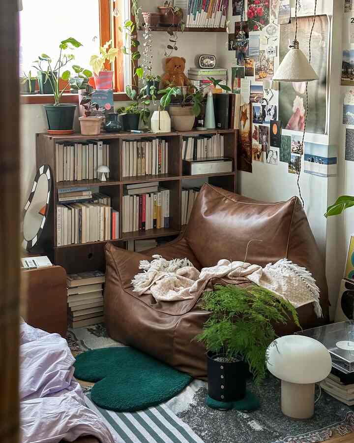 ブラウンのレザー椅子と多彩な植物が配置されたナチュラルなリビングルームのコーナー