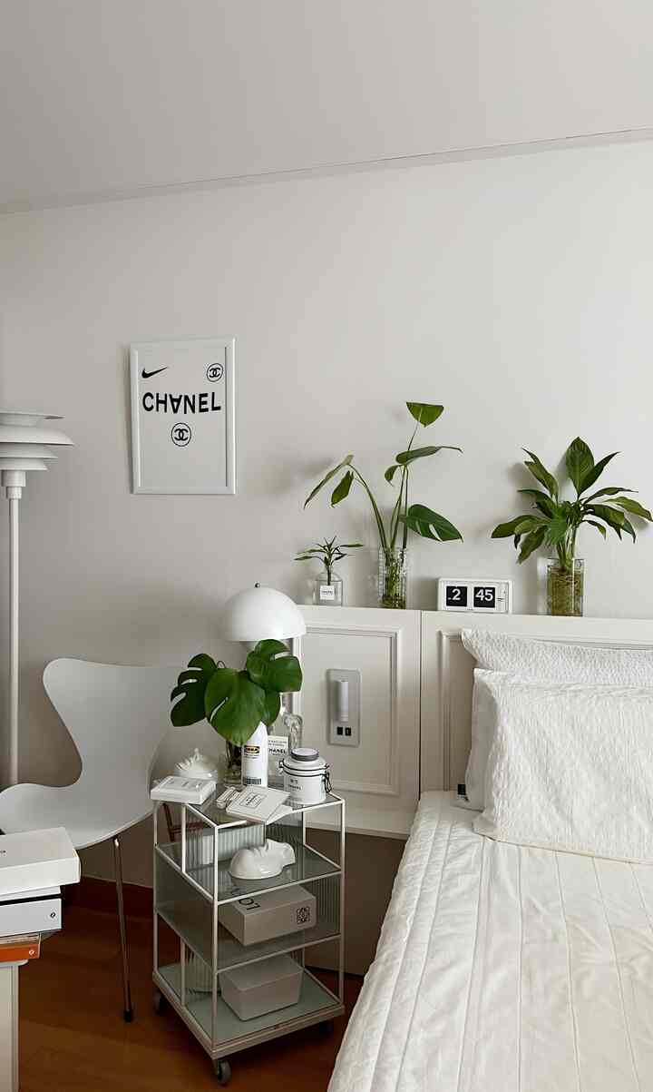 Cozy bedroom in white and wood tones featuring a bed, plants, and minimalist natural decor
