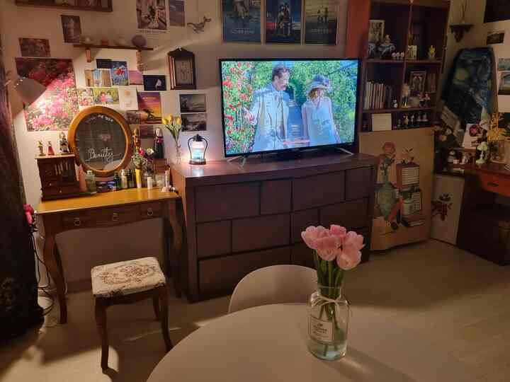 Living room with brown furniture and white flooring featuring posters and a vanity table in a cozy setting